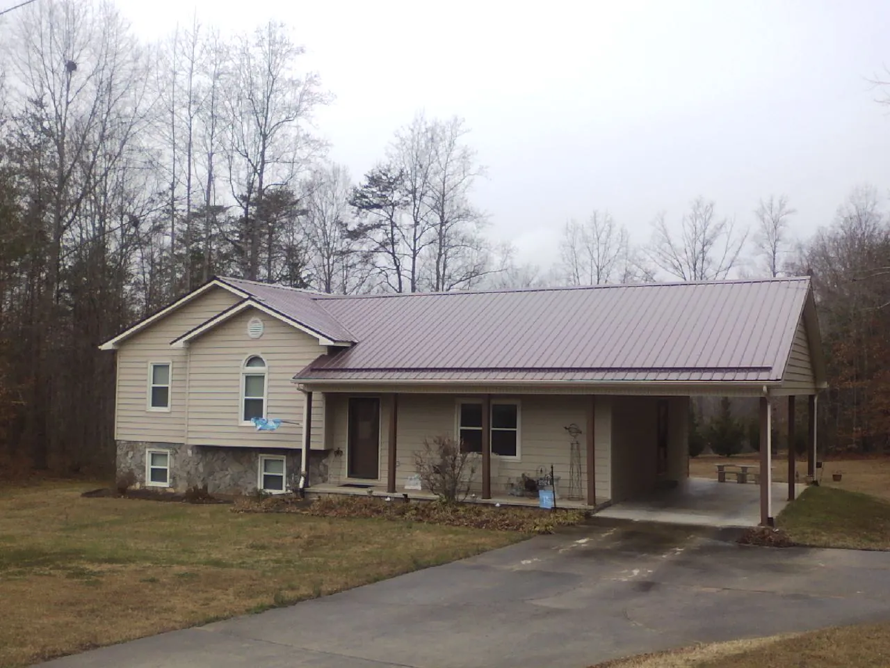 Burgundy metal roof on a tan split level home with an attached carport in Tannersville