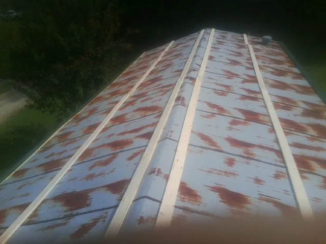 Rusted metal roof panels with new wood purlins before replacement — Storm Damage Roof Repair in Tannersville by Roofing Brothers